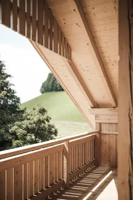a wooden porch with a view of a green field at Zalnerhof Urlaub am Bauernhof in Luson