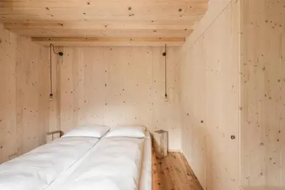 a room with a bed in a wooden wall at Zalnerhof Urlaub am Bauernhof in Luson