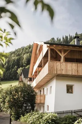 a building with a wooden balcony on top of it at Zalnerhof Urlaub am Bauernhof in Luson