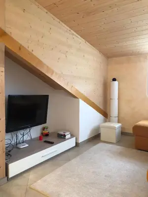 a living room with a flat screen tv on a wall at villa morena in Cavalese