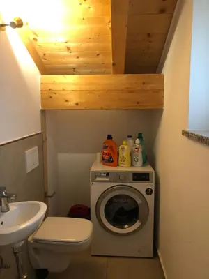 a bathroom with a washing machine and a sink at villa morena in Cavalese