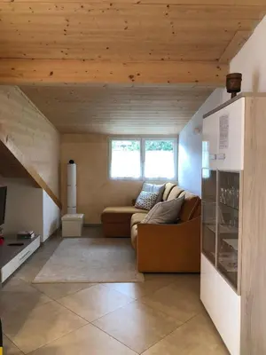 a living room with a couch and some windows at villa morena in Cavalese