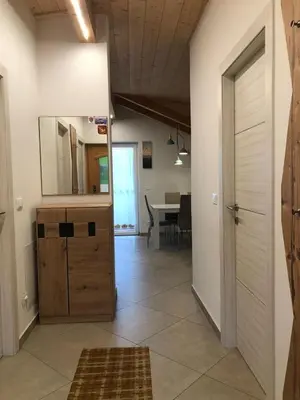 a hallway with a kitchen and a dining room with a table at villa morena in Cavalese