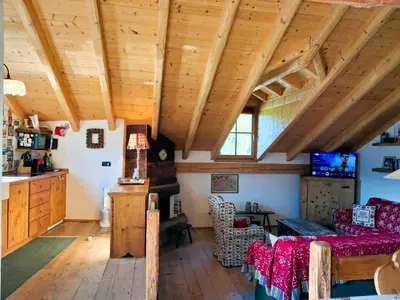 a living room with wooden ceilings and a table at Maso Tre Cucù by Go New Location in Cavalese