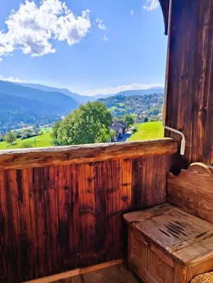 a wooden bench sitting on a balcony with a view at Maso Tre Cucù by Go New Location in Cavalese