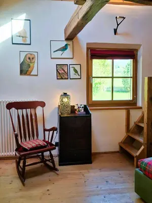 a living room with a chair and a window at Maso Tre Cucù by Go New Location in Cavalese