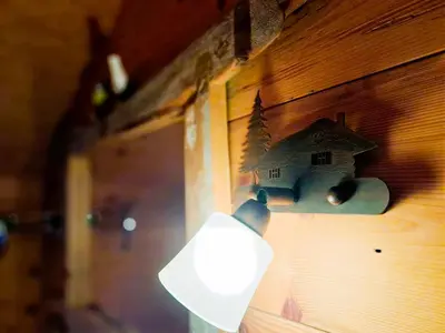 a lamp attached to a wall with a house on it at Maso Tre Cucù by Go New Location in Cavalese