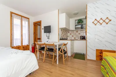 a bedroom with a bed and a table and a kitchen at Suite Civetta in Masarè