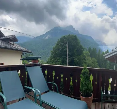 two chairs on a balcony with a view of a mountain at Alpine nest in Val di Zoldo in Forno di Zoldo
