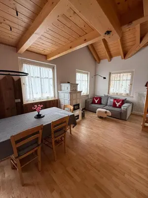 a living room with a table and a couch at Elegante Appartamento in Campitello fi Fassa in Campitello di Fassa