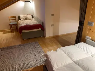 a bedroom with a bed and a chair in it at Elegante Appartamento in Campitello fi Fassa in Campitello di Fassa
