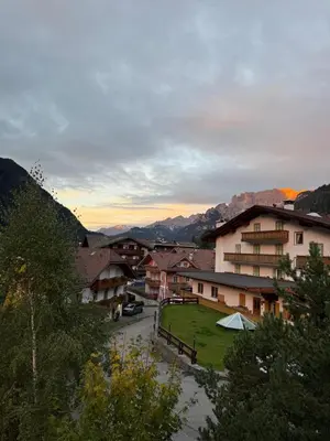 a view of a town with mountains in the background at Elegante Appartamento in Campitello fi Fassa in Campitello di Fassa