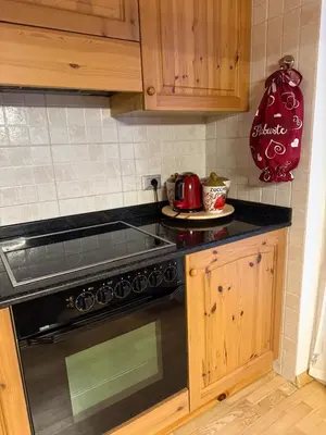 a kitchen with a stove and a tea kettle at Elegante Appartamento in Campitello fi Fassa in Campitello di Fassa