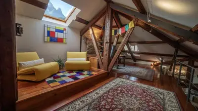 a living room with two chairs and a rug at Dolomites Luxury Penthouse in Agordo