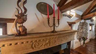 a fireplace with two red candles on top of it at Dolomites Luxury Penthouse in Agordo