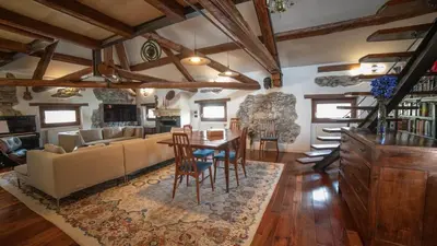 a living room with a couch and a table and chairs at Dolomites Luxury Penthouse in Agordo
