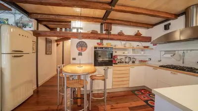 a kitchen with a bar with stools in it at Dolomites Luxury Penthouse in Agordo