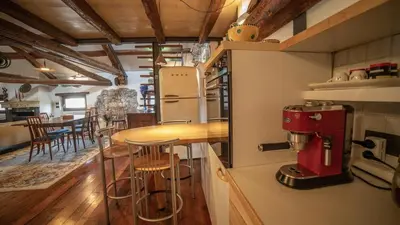 a kitchen with a counter and a table with a coffee maker at Dolomites Luxury Penthouse in Agordo