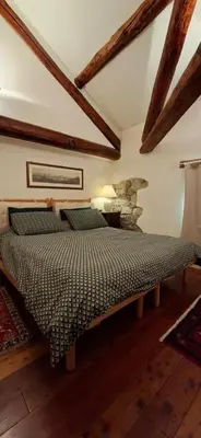 a bedroom with a bed in a room with wooden beams at Dolomites Luxury Penthouse in Agordo