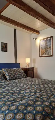 a bedroom with a bed and a table and a picture at Dolomites Luxury Penthouse in Agordo