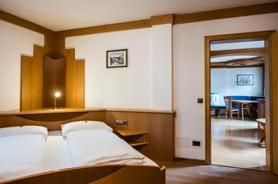 a bedroom with a bed and a dining room at Apartment Vernel in Santa Cristina in Val Gardena