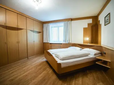 a bedroom with a large bed and wooden cabinets at Apartment Vernel in Santa Cristina in Val Gardena