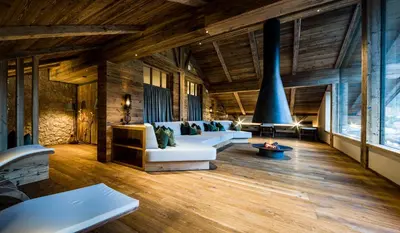 a living room with white furniture and wooden ceilings at Apartment Vernel in Santa Cristina in Val Gardena