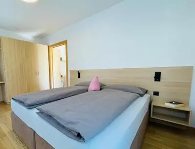 a bedroom with a large bed with a pink pillow at Villa Ehrenburg - Private Apartments in Merano