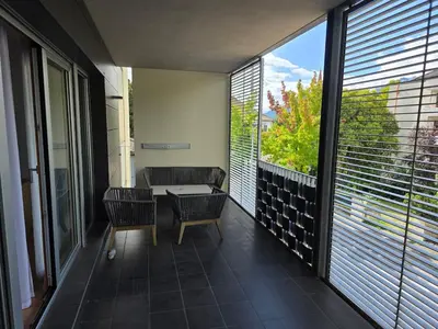 a balcony with a table and chairs and a window at Villa Ehrenburg - Private Apartments in Merano