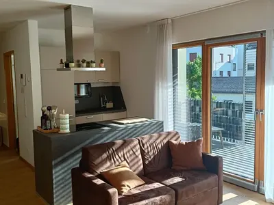 a living room with a couch and a kitchen at Villa Ehrenburg - Private Apartments in Merano