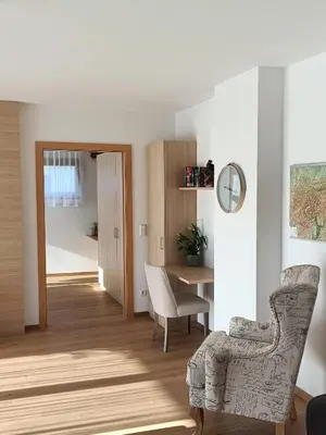 a living room with a chair and a table at Villa Ehrenburg - Private Apartments in Merano