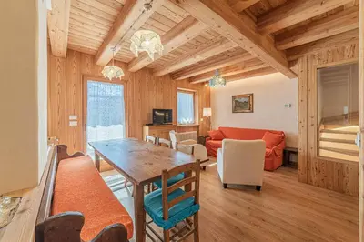 a kitchen and living room with a table and a couch at Chalet Dolomites Heart in Feder