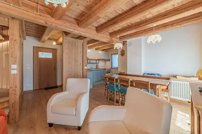a kitchen and dining room with wooden ceilings at Chalet Dolomites Heart in Feder