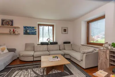a living room with a couch and a table at Appartamento al Rio in Moena