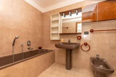 a bathroom with a sink and a bath tub at Appartamento al Rio in Moena
