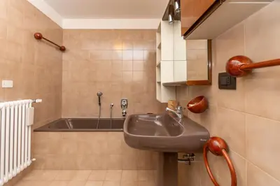 a bathroom with a sink and a bath tub at Appartamento al Rio in Moena