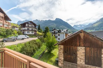 a view from a balcony of a town with mountains at Appartamento al Rio in Moena
