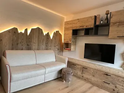 a living room with a couch and a flat screen tv at Cèsa Sabrina in Moena