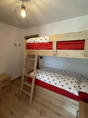 a bedroom with two bunk beds and a ladder at Cèsa Sabrina in Moena