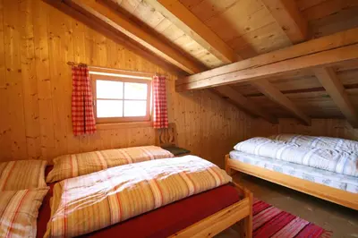 a bedroom with two beds in a log cabin at Almliesl WELS-424 in Monguelfo