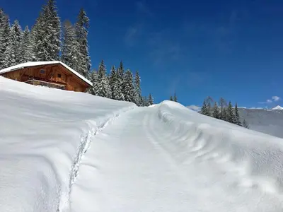 a snow covered path leading to a ski lodge at Almliesl WELS-424 in Monguelfo