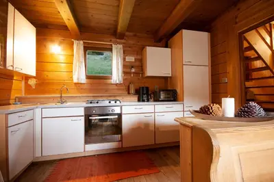 a kitchen with white appliances in a wooden cabin at Almliesl WELS-424 in Monguelfo