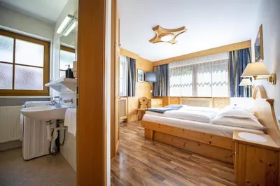 a bedroom with a bed and a sink in a room at Apartments Miara in Santa Cristina in Val Gardena