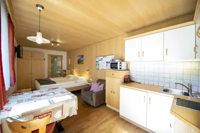 a room with a kitchen and a room with a bed at Apartments Miara in Santa Cristina in Val Gardena