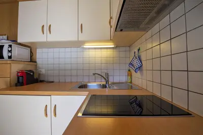 a small kitchen with a sink and white cabinets at Apartments Miara in Santa Cristina in Val Gardena