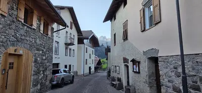 a car parked on a street between two buildings at Condominio de Rocia in Moena