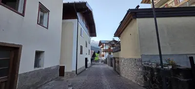 an alley with buildings and a cobblestone street at Condominio de Rocia in Moena