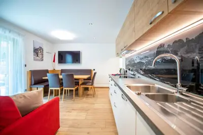 a kitchen with a sink and a table with chairs at Apartments Cesa Ploner in Ortisei
