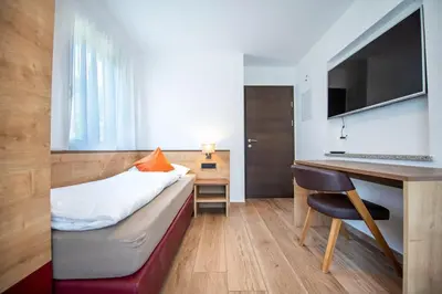 a bedroom with a bed and a desk with a computer at Apartments Cesa Ploner in Ortisei