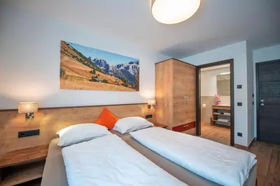 a bedroom with two beds and a mirror at Apartments Cesa Ploner in Ortisei